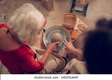 Making kitchenware. Top view of a clay piece lying on ceramics jigger - Powered by Shutterstock