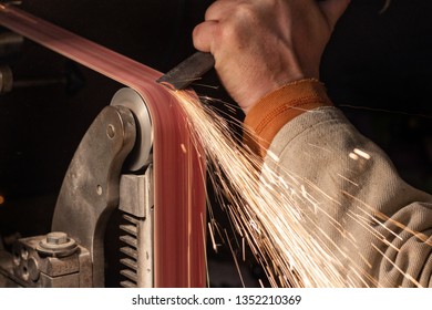 Making knife on the belt grinder with sparks, polishing, sanding handle  - Powered by Shutterstock