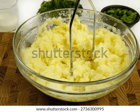 Making mashed potatoes with potato masher, home food
