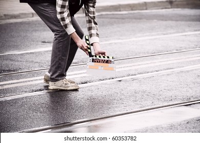 Making Movie And Slate Holding By A Man On Wet Road