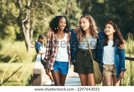 Making new friends and making lots of memories. a group of teenage girls walking and chatting in nature at summer camp.