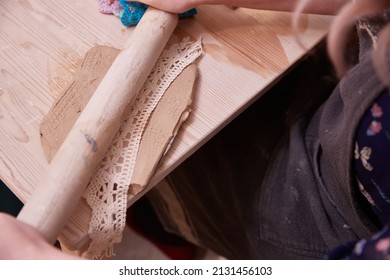 Making an openwork panel made of clay with a knitted napkin and a wooden rolling pin. - Powered by Shutterstock - Get 15% off with code: PIKWIZARD15
