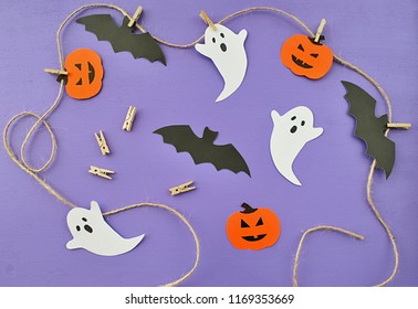 Making Paper Garland With Ghost, Bat And Pumpkin For Halloween Party. Easy Crafts For Kids. Flat Lay On Purple Background.