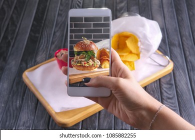 Making Photo With Phone Of Bacon Burger With Nachos On Wooden Plate. Food Blogging.