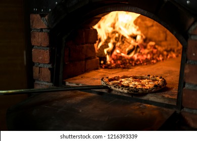 Making Pizza On Wood Fire. Pizza Is Moving Out At Peel From Hot Slove 