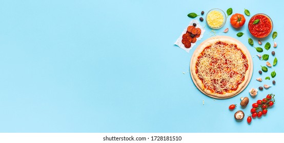 Making Of Pizza Pepperoni, With Raw Dough, Sauce And Cheese And Pizza Ingredients, On A Blue Seamless Background. Flat Lay Of Pizza Preparation.