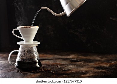 Making pour over coffee with hot water being poured from a kettle