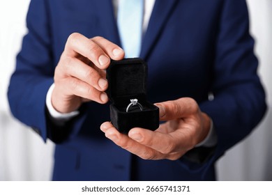 Making proposal. Man with engagement ring indoors, closeup