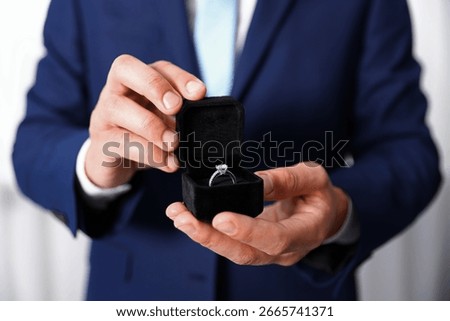 Making proposal. Man with engagement ring indoors, closeup