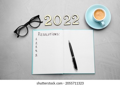 Making Resolutions For 2022 New Year. Flat Lay Composition With Notebook On Light Grey Table