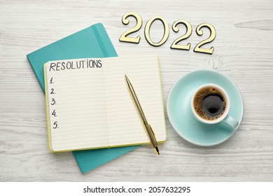 Making Resolutions For 2022 New Year. Flat Lay Composition With Notebook On White Wooden Table