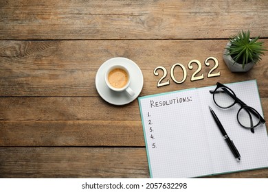 Making Resolutions For 2022 New Year. Flat Lay Composition With Notebook On Wooden Table