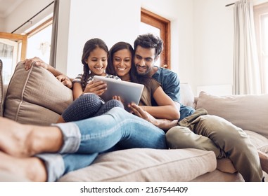 Making screen time bonding time. Shot of a mother and father using a digital tablet with their daughter on the sofa at home. - Powered by Shutterstock