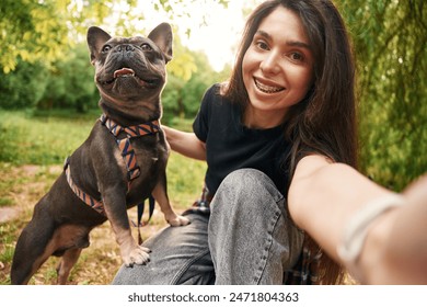 Making a selfie. Young pretty woman is with her dog in the park. - Powered by Shutterstock