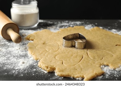 Making shortcrust pastry. Raw dough, flour, cookie cutter and rolling pin on grey table, closeup - Powered by Shutterstock