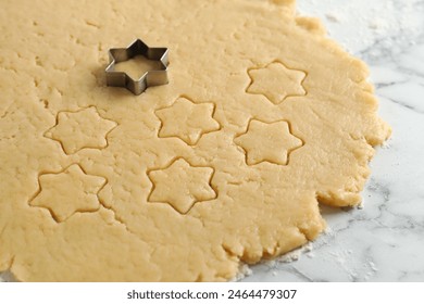 Making shortcrust pastry. Raw dough and cookie cutter on white marble table, closeup - Powered by Shutterstock