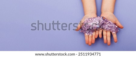 Making slime at home. child holding and stretching colorful slime. DIY concept. Very Peri