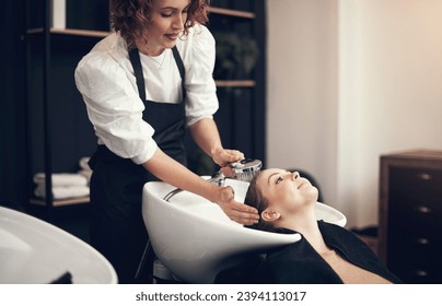 Making sure its clean from root to tips. Shot of a beautiful young woman getting her hair washed at the salon. - Powered by Shutterstock