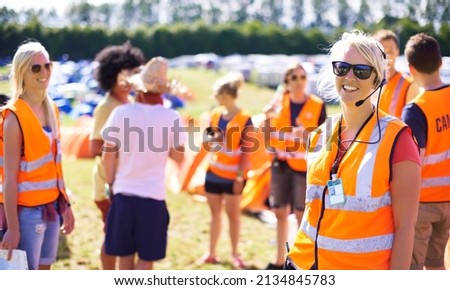 Making sure the event goes off without a hitch. Shot of a beautiful young woman working as an event assistant at a music festival.