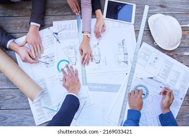 Making Sure Its Perfect. High Angle Shot Of A Diverse Group Of Businesspeople Huddled Around Building Plans.