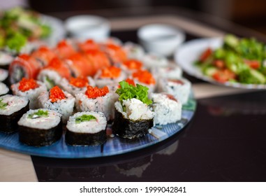 Making Sushi And Rolls At Home. Sushi With Seafood, Salad And White Rice. Food For Family And Friends. A Set Of Different Rolls And Sushi On A Tray.