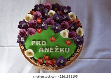 Making a sweet birthday cake with marzipan flowers and name Anežka.