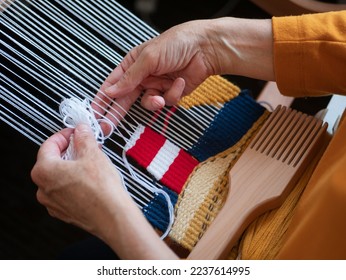Making a tapestry with an image of lighthouse, selective focus. Creating handmade wall decoration using weaving loom, beater and threads. Hobby concept - Shutterstock ID 2237614995