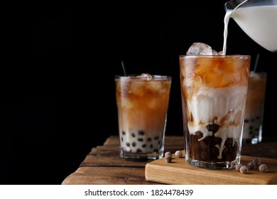 Making tasty milk bubble tea on wooden table. Space for text