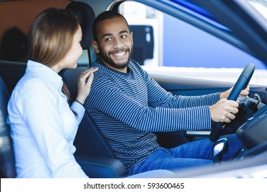 Making Their Decision. Beautiful Interracial Loving Couple Sitting In A New Car Together At The Dealership Handsome African Man And His Loving Girlfriend Choosing A Car Together Consumerism Vehicle