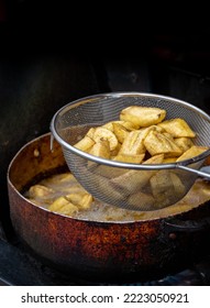 The Making Of Tostones, Dominican Deep Fried Plantains, Fried In Sizzling Oil, Crushed And Fried Again. Typical Homemade Family Food Or Snack.