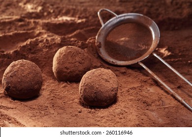 Making Truffle Chocolate Candies On Cocoa Powder Background