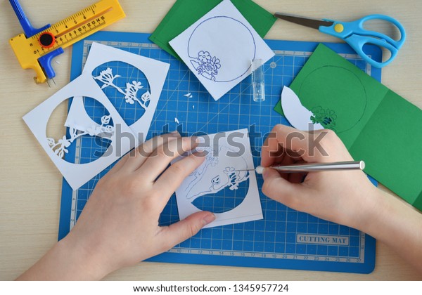 Making  tunnelbook. 3D greeting card "Spring". Artwork equipment and tools for paper cut - cutting knife, sharp box cutter, blue cutting plate, origami paper. Modern 3d origami paper art style.