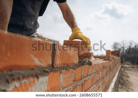 Making the wall. Close up view of construction man that is working with bricks.