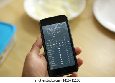 Malacca,Malaysia- 3 June 2019. A Women Holding Smart Phone And Launching Weather Podcast Application That Easy For Her To The Day Activities.