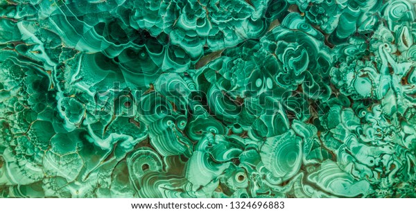 Malachite green mineral gemstone\
texture,malachite background, green background. Amazing polished\
natural slab of green malachite mineral gemstone specimen gemstone\
macro as a background