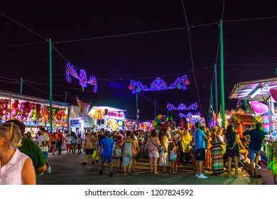The Malaga fair at night, Feria de Malaga. People enjoying the fair attractions and night lights. 
