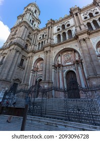 Malaga Spain - 09 15 2021: View At The Front Facade At The Malaga Cathedral Or Santa Iglesia Catedral Basílica De La Encarnación, And Obispo Square With Tourist People