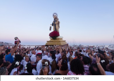 MALAGA, SPAIN - JULY 16: Unidentified local worshiper lift his daughter in front of a religious image at the beach during the 'Virgen del Carmen' festival on July 16, 2013 in Malaga, Spain.