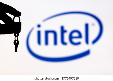 Malaga, Spain - May 18th, 2020: Intel Security. Hand Holding A Locked Padlock With A Key Besides An Intel Logo