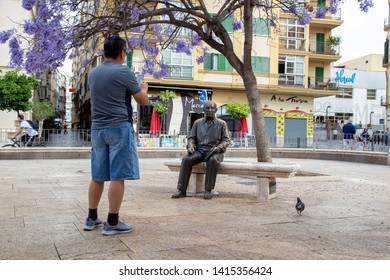 Malaga, Spain - May 24, 2019: A Tourist Taking A Photo Of The Statue Of Painter And Sculptor Pablo Picasso. It Was Made By Francisco Lopez Hernandez And Was Inaugurated In 2008.