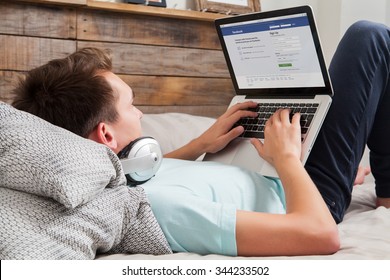 MALAGA, SPAIN - NOVEMBER 10, 2015: Facebook login page in a laptop screen. Man holding a laptop on her knees while type on the keyboard. Facebook is the most famous social website all over the world.