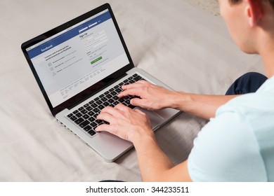 MALAGA, SPAIN - NOVEMBER 10, 2015: Facebook Login Page In A Laptop Computer Screen. Man Typing On The Keyboard. Facebook Is The Most Famous Social Media Website All Over The World.