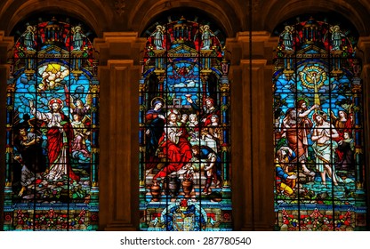 MALAGA, SPAIN - NOVEMBER 29, 2013: Stained glass window depicting Jesus casting away Lucifer, the Wedding at Cana and the baptism in the River Jordan by Saint John, in the cathedral of Malaga, Spain.