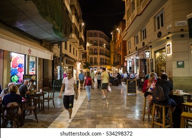 MALAGA, SPAIN - OCTOBER, 2016: Cityscape. View Of The Street Cafe At Night With Visitors.
