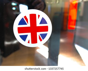 Malaga/Spain - 03-10-2019 : Round Sticker With The British Flag On The Glass Window Of A Store.