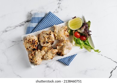 Malai Chicken Kebab bbq with lime in a dish isolated on napkin side view on grey background