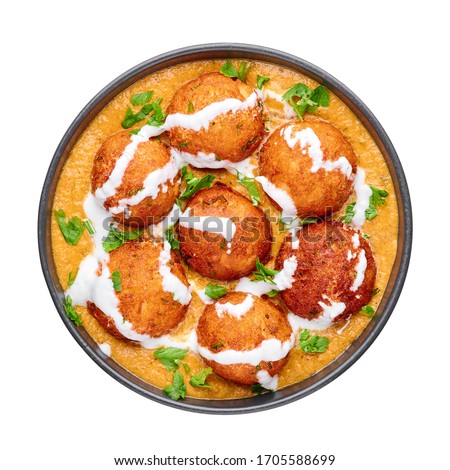 Malai Kofta Curry in black bowl isolated on white background. Malai Kofta is indian cuisine dish with potato and paneer cheese deep fried balls in onion tomato gravy with spices. Indian Food.