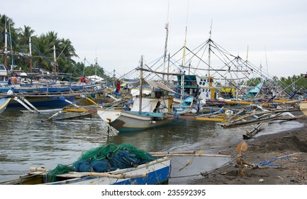 Malandog,Panay Island, Philippines - December 4,2014: Fishermen Putting Outriggers Out In The River To Protect The Boats From Super Typhoon Hagupit (Ruby)