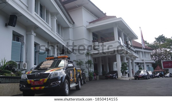 Malang, Indonesia - 10 October 2018: a police\
car parked near this building creates a harmony that the police\
stay together and protect the\
community