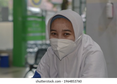 Malang, Indonesia -17 April, 2021: A Female Nurse In Indonesia In An Outpatient Room Wears A Mask And Is On Duty In The Morning Shift